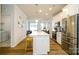 Open kitchen featuring stainless steel appliances, a large island, and hardwood floors, ideal for cooking at 8157 Merryvale Ln, Charlotte, NC 28214