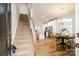 Spacious living room featuring a staircase, an open dining area, hardwood floors and natural light at 8157 Merryvale Ln, Charlotte, NC 28214