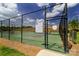 Outdoor pickleball court with a black fence, green surface, and an information sign visible under a partly cloudy sky at 8157 Merryvale Ln, Charlotte, NC 28214