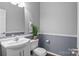 Cozy bathroom features a toilet, sink and a mirror with decorative accents and neutral tones to add character at 8932 Raven Park Dr, Charlotte, NC 28216