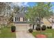 Charming two-story home with a well-maintained lawn, mature trees, and a two-car garage at 8932 Raven Park Dr, Charlotte, NC 28216