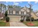 A charming two-story home with a two-car garage, mature trees, and a well-manicured lawn at 8932 Raven Park Dr, Charlotte, NC 28216