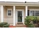 Welcoming front door with sidelights, columns, and manicured shrubs offering classic elegance at 8932 Raven Park Dr, Charlotte, NC 28216