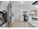Bright kitchen featuring sleek stainless steel appliances, white cabinetry, and an eye-catching backsplash, creating a stylish cooking space at 8932 Raven Park Dr, Charlotte, NC 28216