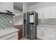 Bright kitchen showcases stainless steel refrigerator, white cabinets, modern backsplash, and a spacious countertop creating inviting space at 8932 Raven Park Dr, Charlotte, NC 28216