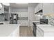Bright kitchen boasts white cabinets, stainless steel appliances, and eye-catching tile backsplash, creating a modern and functional space at 8932 Raven Park Dr, Charlotte, NC 28216