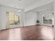 Open-concept living room with hardwood floors and large windows providing natural light at 8932 Raven Park Dr, Charlotte, NC 28216