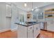 Bright kitchen with stainless steel appliances, island cooktop and floating shelves at 1006 N Ridge Ave, Kannapolis, NC 28083