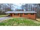 Charming red brick home featuring a metal roof, black shutters, and well-maintained landscaping at 104 Pop Davis Rd, Taylorsville, NC 28681