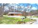 Charming brick home features a metal roof, a spacious driveway, and a lush green lawn at 104 Pop Davis Rd, Taylorsville, NC 28681