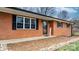 Close-up of a charming brick home with black shutters and a welcoming entrance at 104 Pop Davis Rd, Taylorsville, NC 28681