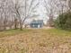 Landscaped backyard featuring a quaint blue home surrounded by mature trees, on a sunny day at 1137 Williams St, Rock Hill, SC 29732