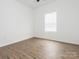 Bright bedroom featuring neutral walls, wood-look flooring, and a window with blinds for natural light at 1137 Williams St, Rock Hill, SC 29732