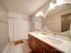 Modern bathroom with double vanity, round mirrors, and tiled shower at 1207 Lakedell Dr, Charlotte, NC 28215