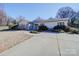 Lovely home showcasing a concrete driveway, stone accents, and manicured landscaping, bathed in sunlight at 1207 Lakedell Dr, Charlotte, NC 28215