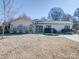 Beautifully landscaped one-story home with stone details, complemented by a lush yard on a sunny day at 1207 Lakedell Dr, Charlotte, NC 28215