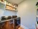 Laundry room with hardwood floors, laundry units, and shelving at 1207 Lakedell Dr, Charlotte, NC 28215