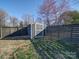 Fenced backyard featuring a storage shed and mature trees providing natural shade at 1207 Lakedell Dr, Charlotte, NC 28215