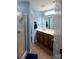 This blue bathroom features a shower with glass doors, tile floor, and a vanity with double sinks at 12123 Monteith Grove Dr, Huntersville, NC 28078