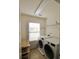 This laundry room includes a front loading washer and dryer, storage shelf, and a window at 12123 Monteith Grove Dr, Huntersville, NC 28078