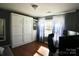 This office space features a Murphy bed with built in shelving, wood floors, and lots of natural light at 12123 Monteith Grove Dr, Huntersville, NC 28078