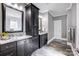 Bathroom with double sink vanity, marble countertops, dark cabinets, and decorative tile flooring at 125 Arrow Point Ln, Davidson, NC 28036