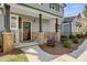 Inviting front porch with stone accents, wood columns, and professionally landscaped garden at 125 Arrow Point Ln, Davidson, NC 28036