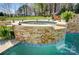 The in-ground hot tub features decorative stone and a relaxing waterfall feature flowing into the pool at 125 Arrow Point Ln, Davidson, NC 28036