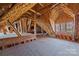 Spacious unfinished attic with exposed wooden beams, insulation, and a window at 134 Larkhaven Ln, Mooresville, NC 28117