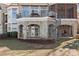 Stunning exterior featuring stone accents, a spiral staircase, a balcony, and a covered patio with lake views at 134 Larkhaven Ln, Mooresville, NC 28117