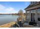 Exterior elevation showcasing a stone patio, a grill, and a beautiful lake view at 134 Larkhaven Ln, Mooresville, NC 28117