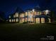 Expansive waterfront estate featuring multiple balconies and beautiful architecture at twilight at 134 Larkhaven Ln, Mooresville, NC 28117