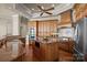 Spacious kitchen featuring an island, granite countertops, wooden cabinetry, and stainless steel appliances at 134 Larkhaven Ln, Mooresville, NC 28117