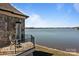 Stone home featuring a balcony with intricate railings and expansive lake views on a bright, sunny day at 134 Larkhaven Ln, Mooresville, NC 28117