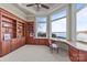 Bright office space with lake views, built-in wood shelving and cabinets, and a comfortable seating area at 134 Larkhaven Ln, Mooresville, NC 28117