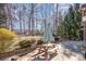 Backyard patio area with a picnic table and shade, set amongst established trees at 158 Crimson Orchard Dr, Mooresville, NC 28115
