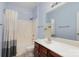 Bathroom features a shower-tub combo with white tile, a dark wood vanity, and a large mirror at 158 Crimson Orchard Dr, Mooresville, NC 28115