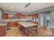 Open kitchen with wood cabinetry, stainless appliances, granite counters, and island seating at 158 Crimson Orchard Dr, Mooresville, NC 28115