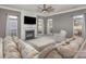 Cozy living room featuring a fireplace, ceiling fan, neutral color palette, and natural light at 158 Crimson Orchard Dr, Mooresville, NC 28115
