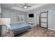 A spacious main bedroom with wood floors, a ceiling fan, and a sliding barn door at 158 Crimson Orchard Dr, Mooresville, NC 28115