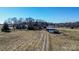 Aerial view of a rural landscape with scattered buildings, fields, and a dirt road at 169 Eagle Mills Rd, Harmony, NC 28634