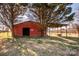 Exterior of a red barn with a large opening surrounded by mature trees at 169 Eagle Mills Rd, Harmony, NC 28634