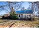Charming, historic two-story home featuring a brick facade, blue metal roof, and a quaint front entrance at 169 Eagle Mills Rd, Harmony, NC 28634