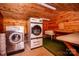 Rustic laundry room with wood walls and industrial laundry machines at 169 Eagle Mills Rd, Harmony, NC 28634