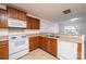 Well-lit kitchen with white appliances, wood cabinets and a view to the living area at 1991 9Th Street Se Pl, Hickory, NC 28602