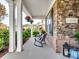 Charming front porch featuring stone accents, hanging flower baskets, and a cozy seating area at 2033 Folkstone Ln, Indian Land, SC 29720