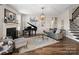 Elegant living room with fireplace, piano, hardwood floors, and stylish furniture at 2033 Folkstone Ln, Indian Land, SC 29720