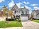 Charming two-story home with stone and siding exterior, well-manicured lawn, and attached garage at 2033 Folkstone Ln, Lancaster, SC 29720
