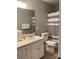 Well-lit bathroom with white vanity, toilet, and gray striped shower curtain at 2049 Winding Oak Rd, Rock Hill, SC 29732