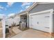 Home exterior featuring an attached garage, covered patio and partial view of the white picket fence at 2130 Blewett Dr, Charlotte, NC 28269